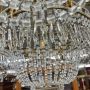 Lampadario dei primi del '900 a 8 luci in metallo dorato con gocce di cristallo