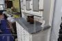 Vintage high cupboard in white wood with small drawers and marble top