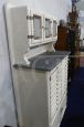 Vintage high cupboard in white wood with small drawers and marble top