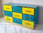 Design chest of drawers with 9 drawers in yellow and blue glass