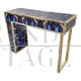 Asymmetric design console in backlit blue and gold glass