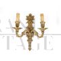 Pair of baroque style wall lights in golden brass                            