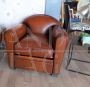 Classic style club armchair in brown leather with rounded shapes