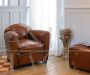 Classic style club armchair in brown leather with rounded shapes